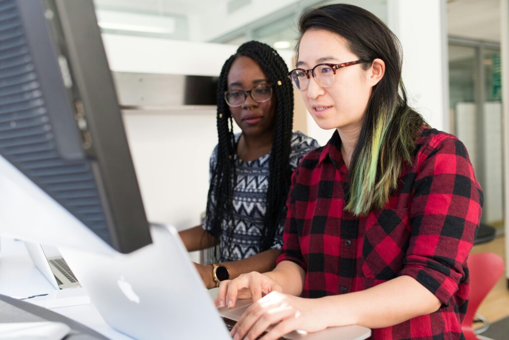 Woman assisting non-profit worker in grant development.